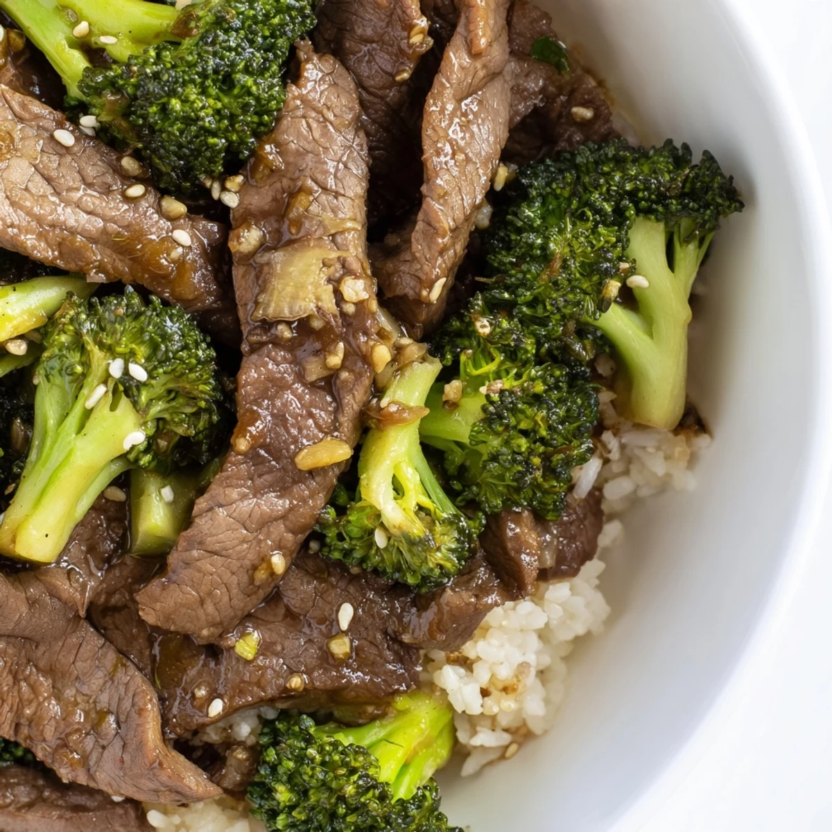 Tender beef and broccoli stir-fry glistening with a savory sauce, served over fluffy rice.
