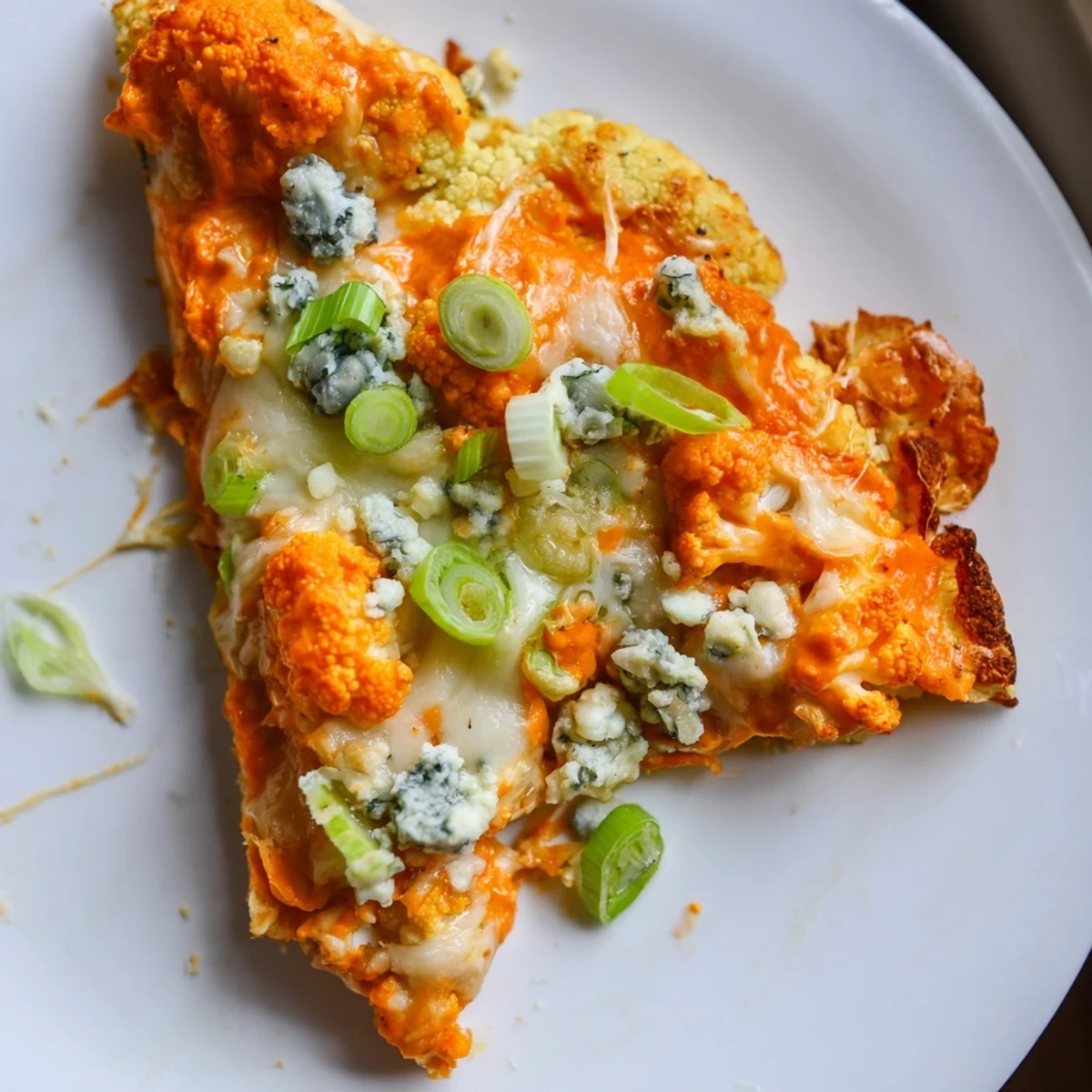 Vegetarian Buffalo Cauliflower Pizza with bubbly cheese and buffalo sauce, served with extra celery sticks for dipping.