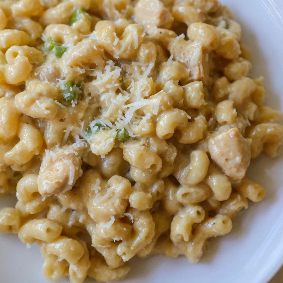 In a skillet, creamy Green Chili Chicken Mac steams beside cilantro and jalapeño, with melted Monterey Jack and cheddar cheeses.