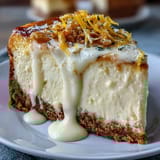 Bright limoncello cheesecake bars with buttery graham cracker crust, garnished with lemon zest for a refreshing citrus dessert.