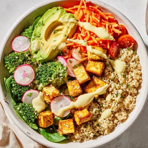 A colorful Buddha bowl overflowing with quinoa, tofu, and vibrant vegetables, ready to eat.