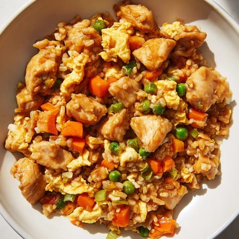 Savory chicken fried rice piled high, with visible egg swirls and fresh green onions.