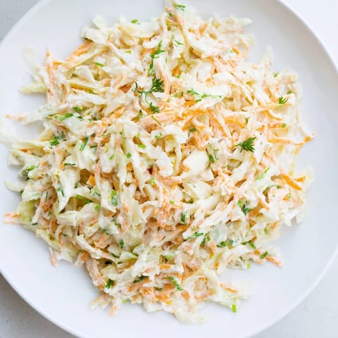 A vibrant, crunchy bowl of coleslaw with apple, perfect side dish for a summer barbecue.