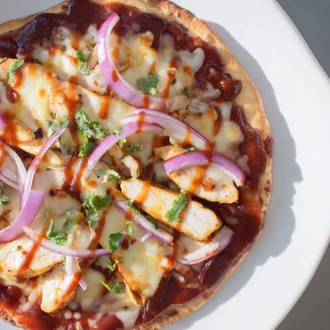 Delicious, homemade chicken BBQ pizza boasting grilled chicken, flavorful sauce, and melted cheese, sizzling hot.