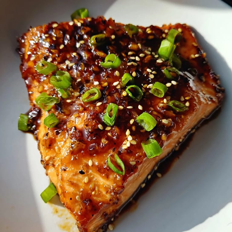 A close-up of sizzling Honey Garlic Salmon, glistening with a sticky, flavorful sauce.