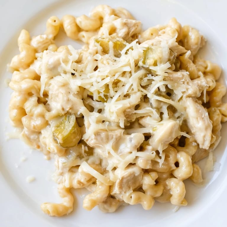 Sizzling skillet of Green Chili Chicken Mac garnished with fresh cilantro and jalapeño slices, perfect for a cozy Southwestern-inspired dinner.