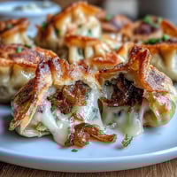 Crispy caramelized French onion soup dumplings filled with gooey Gruyère and topped with fresh chives.  
