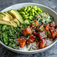 Fresh Salmon Poke Bowl piled high with vibrant avocado and edamame.